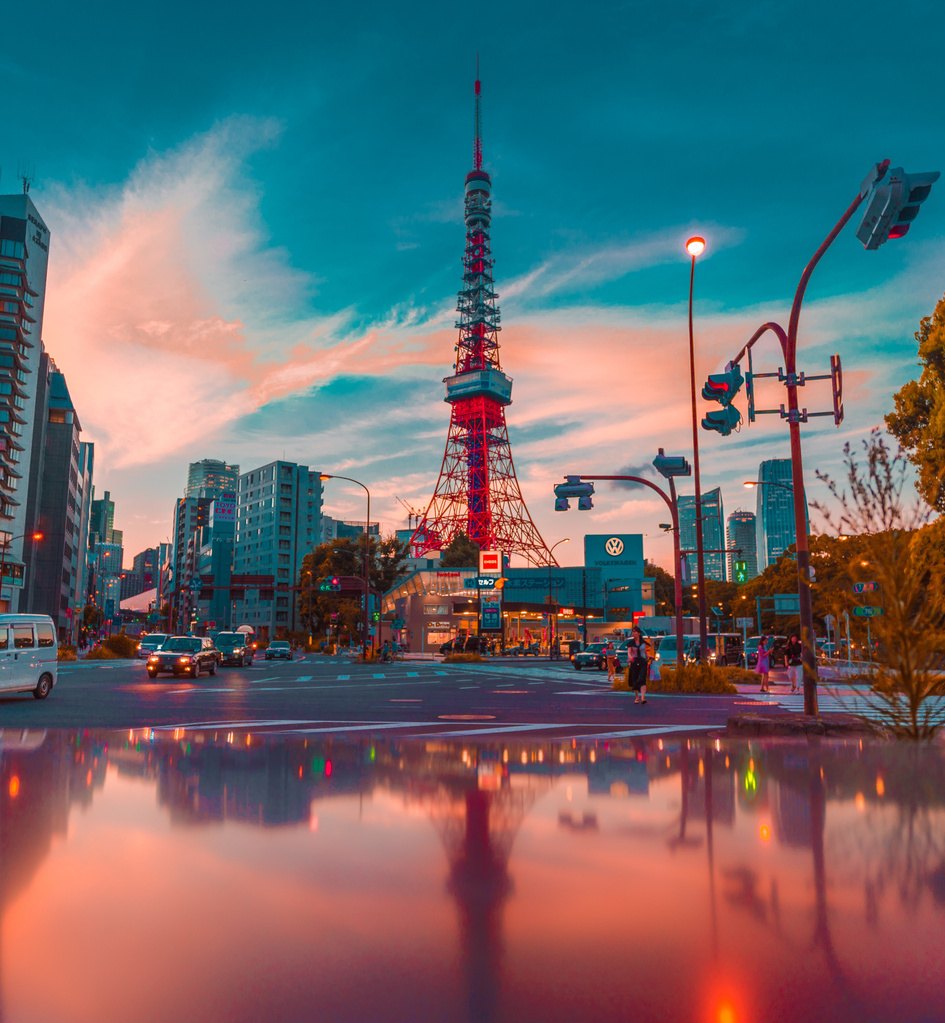 Tokyo Tower lit in warm evening light above a city crossing